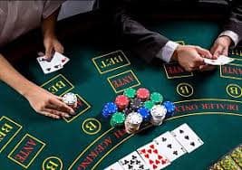Meja Live Casino dengan dealer sedang melayani pemain menggunakan latar belakang warna ungu gelap